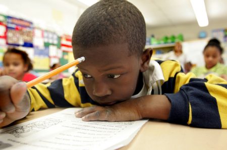 Second grade student Kaign Groce, 7, reads a book Wednesday, Feb. 1, 2006, during a literacy class at the John Fenwick Elementary School in Salem, N.J. New state data show fourth-graders in poor districts like Salem have been making big strides on standardized test. Officials say the progress is because of overhauled teaching methods in lower grades.(AP Photo/ Jose F. Moreno)